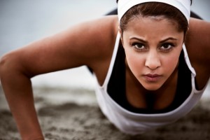 A beautiful asian woman doing push up at a beach