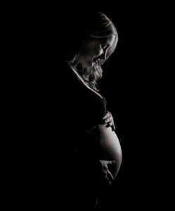 Pregnancy Chiropractic Care Colorado Springs - Dramatic Photo of a Pregnant Woman Holding Herself