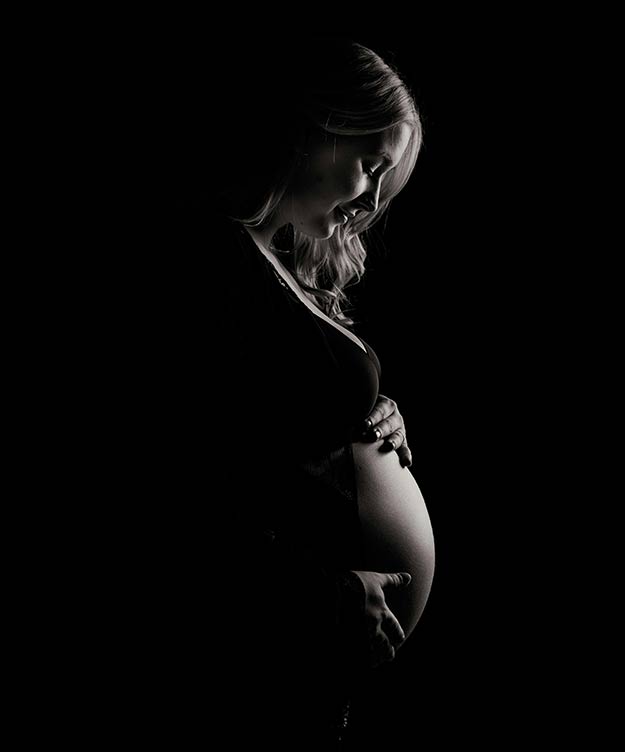 Pregnancy Chiropractic Care Colorado Springs - Dramatic Photo of a Pregnant Woman Holding Herself